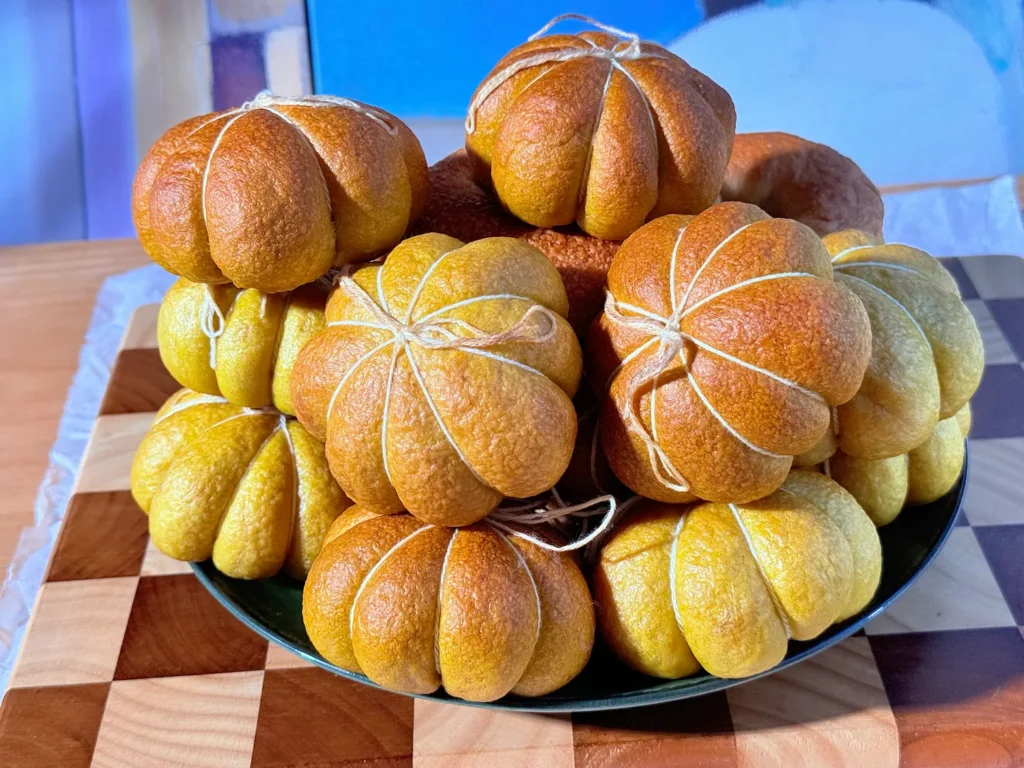 Bagels con forma de calabaza de los dos lotes juntos, unos hechos con puré de calabaza y otros solo con cúrcuma