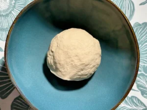 Bola de masa de bagels recién amasada en el bol, antes de la primera fermentación