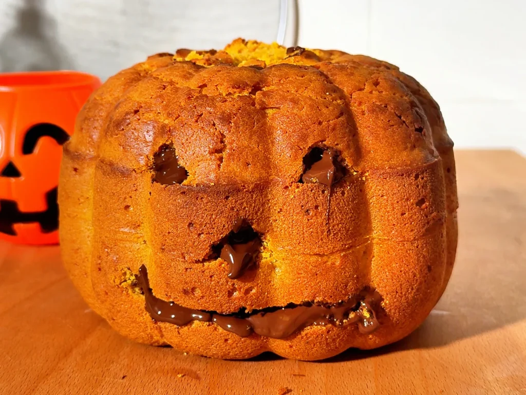 Bizcocho de calabaza y boniato con forma de calabaza de Halloween y la cara rellena de chocolate
