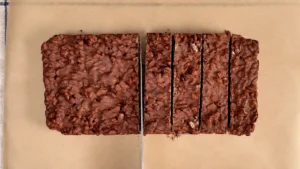 Turrón de chocolate crujiente cortado en tiras con un cuchillo grande