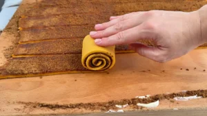 Enrollando en espiral una tira de masa de calabaza con relleno de canela