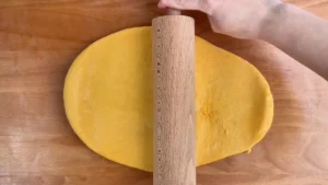 Estirando con el rodillo la masa naranja de los cinnamon rolls de calabaza