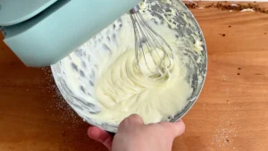 Batiendo el frosting de queso crema con una batidora de varillas