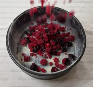 Echando frutos rojos congelados en el molde untado con mantequilla