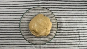 Masa de brioche de masa madre después de la primera fermentación, en un bol de cristal