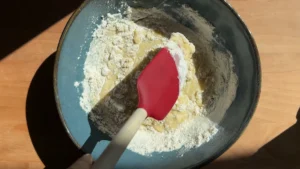 Mezclando la harina con una espátula en la masa de gofres de plátano