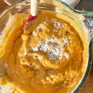Incorporando la harina a la masa de bizcocho de calabaza con una espátula