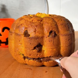 Rellenando la boca de la calabaza de bizcocho con chocolate fundido con una manga pastelera