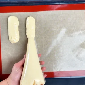 Formando soletillas con manga pastelera sobre un tapete de silicona