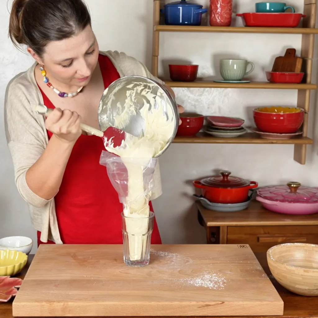 Llenando la manga pastelera dentro de un vaso alto para que no se caiga la masa