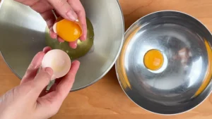 Separando la clara y la yema de cada huevo en boles distintos para hacer soletillas