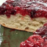 Tarta brioche de masa madre cortada, con la miga esponjosa y los frutos rojos caramelizados por encima